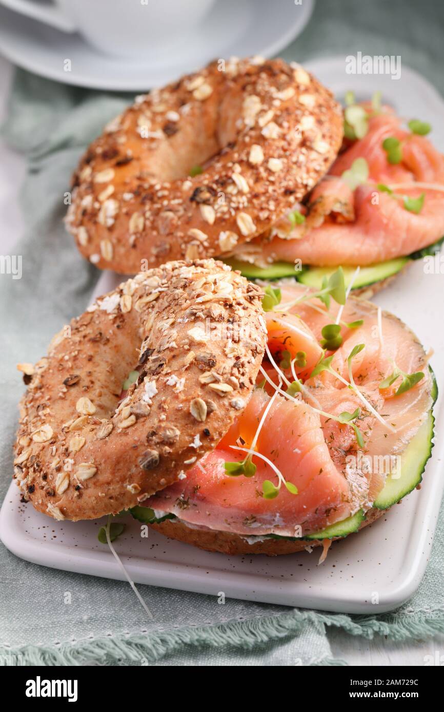 Two bagel sandwiches with sliced salt salmon, cream cheese, cucumber, and micro greens closeup Stock Photo
