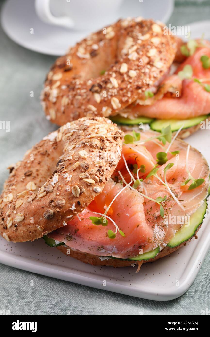 Two bagel sandwiches with sliced salt salmon, cream cheese, cucumber