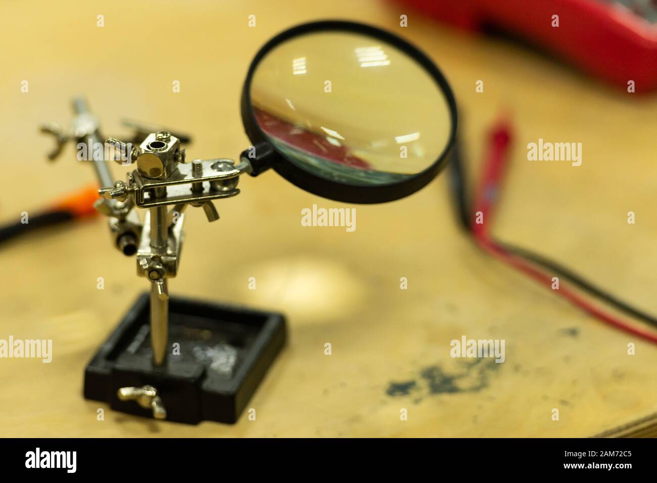 Magnifier. Tool for precise soldering. Magnifying glass in the electronics repair shop. Stock Photo