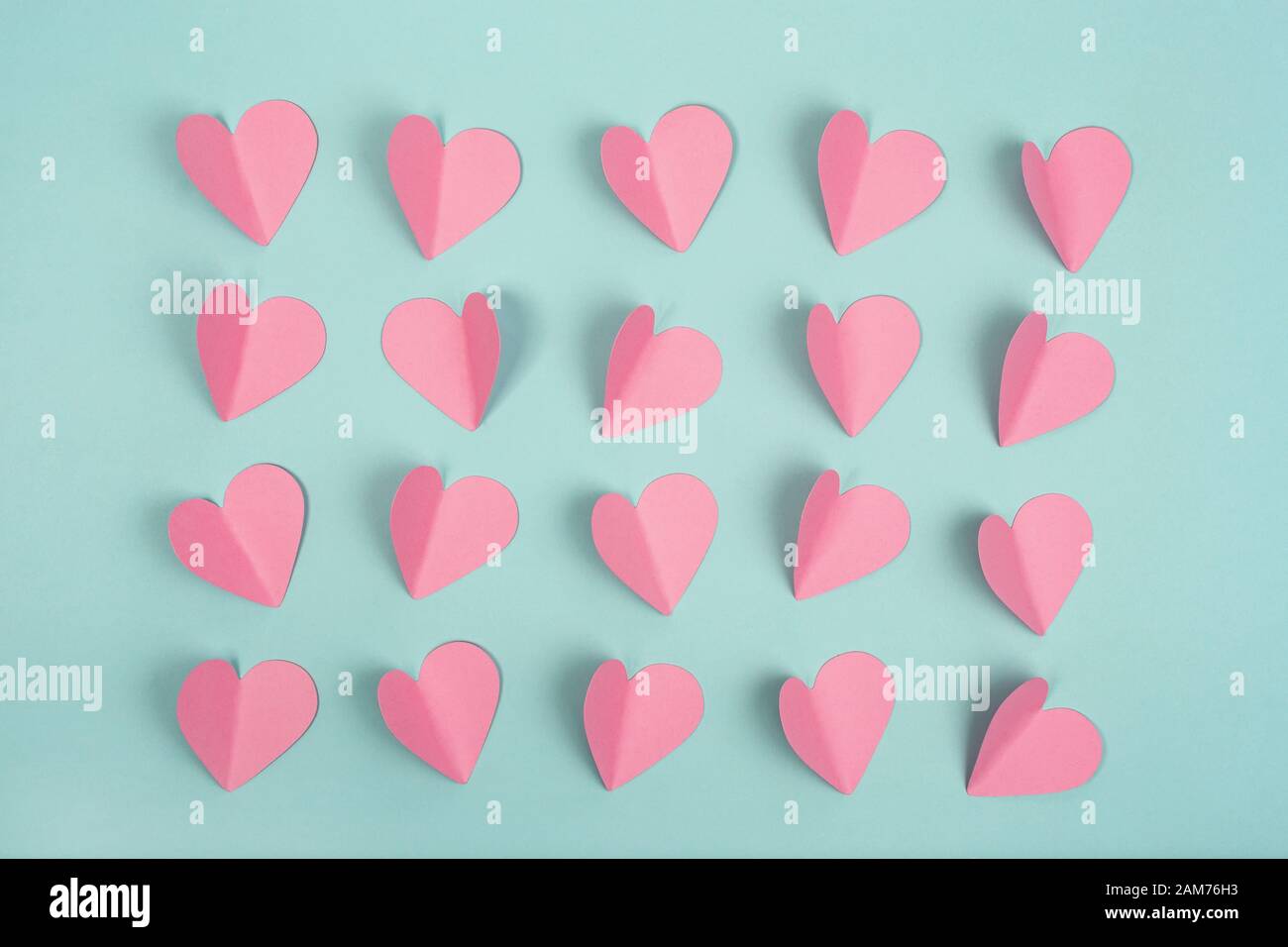 Pink paper hearts on mint background. Flat lay. Stock Photo