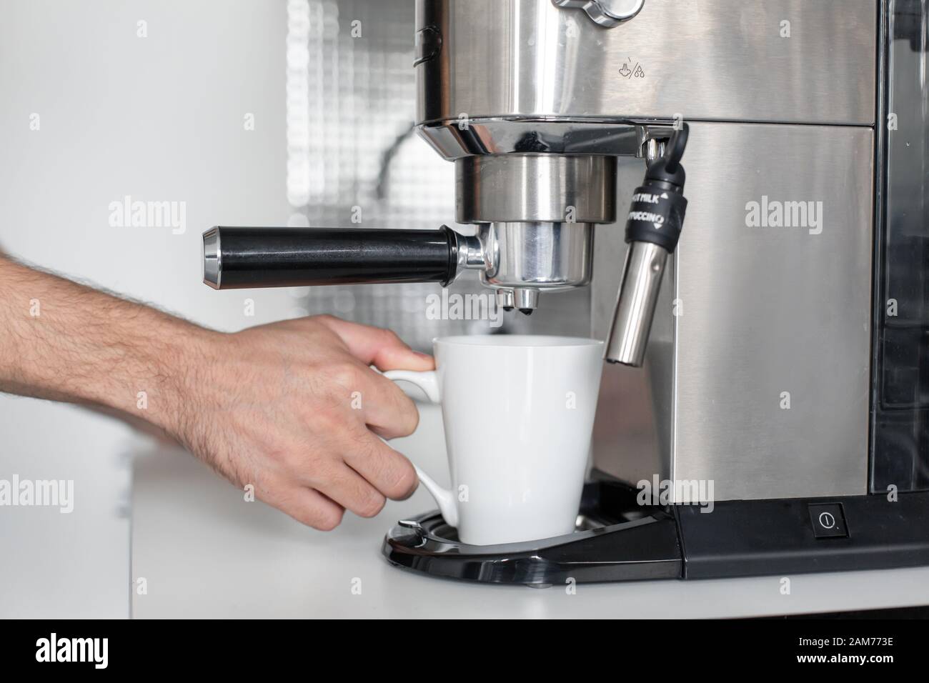 Guy prepare delicious aromatic coffee in a coffee machine. A simple way