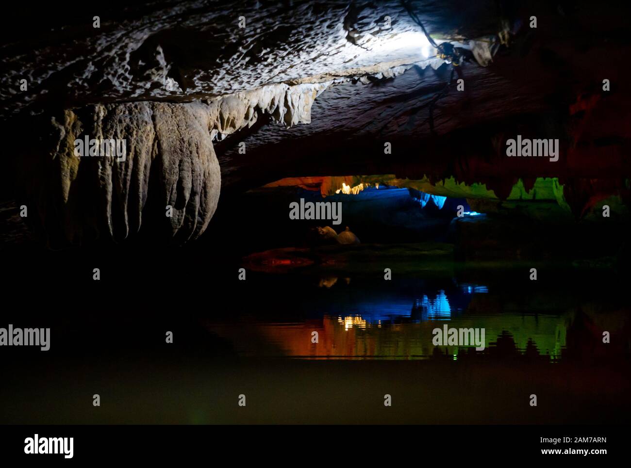 Thien Thanh cavern stalactites lit up with coloured lights reflected in water, Tam Coc cave system, Ninh Binh, Vietnam, Asia Stock Photo