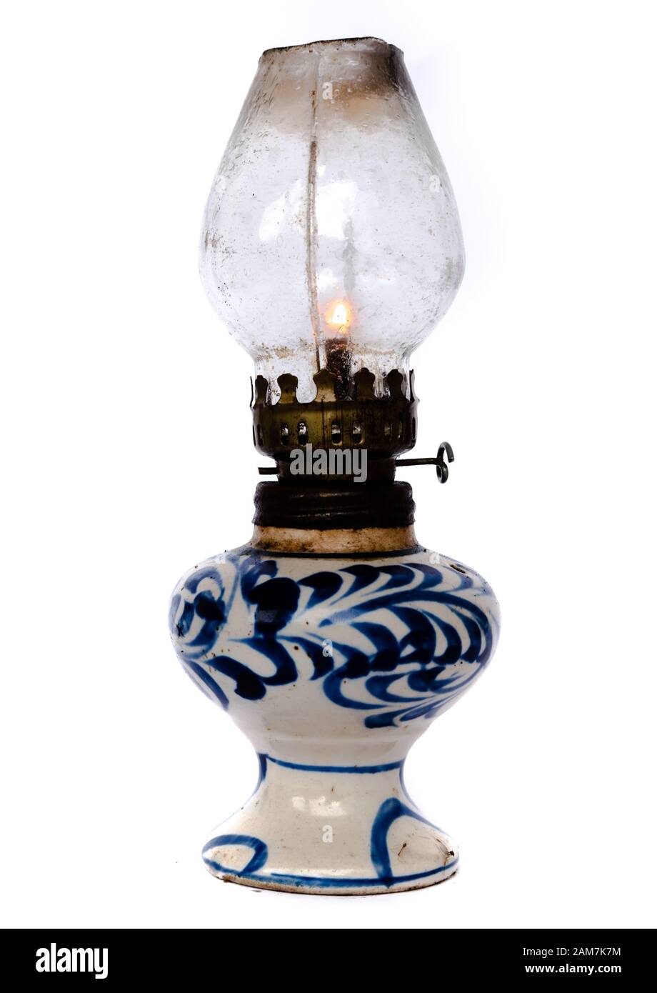 Studio shot burning light in traditional Vietnamese oil lamp isolated