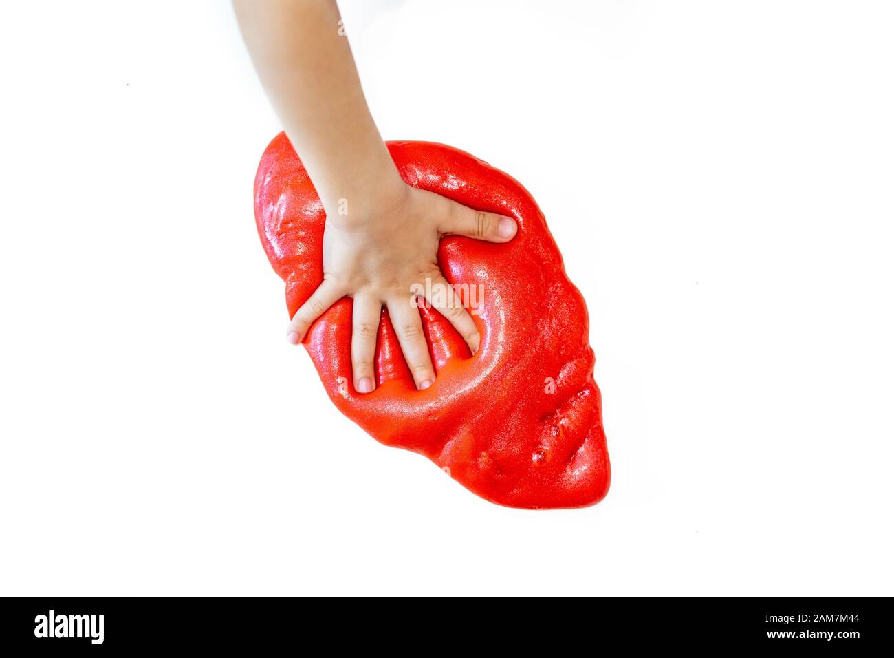 Kid playing red glitter slime with hand on white background Stock Photo