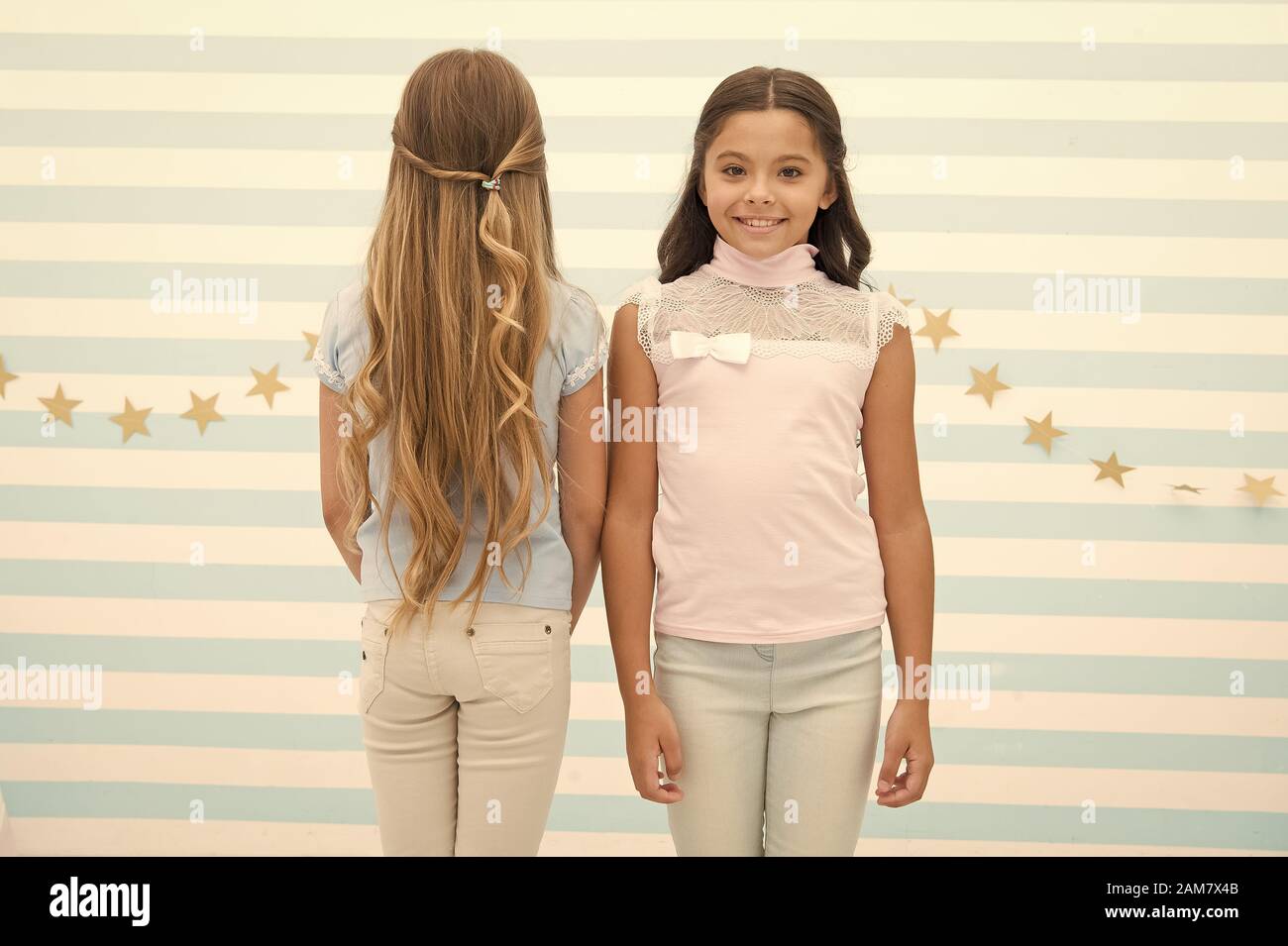 Brunette and blonde. Hairdresser salon services. Little kids with long hair.  Small girls with long curly hair. Healthy hair. Shampoo conditioner balm  and mask. Curling styling. Beautiful curls Stock Photo - Alamy