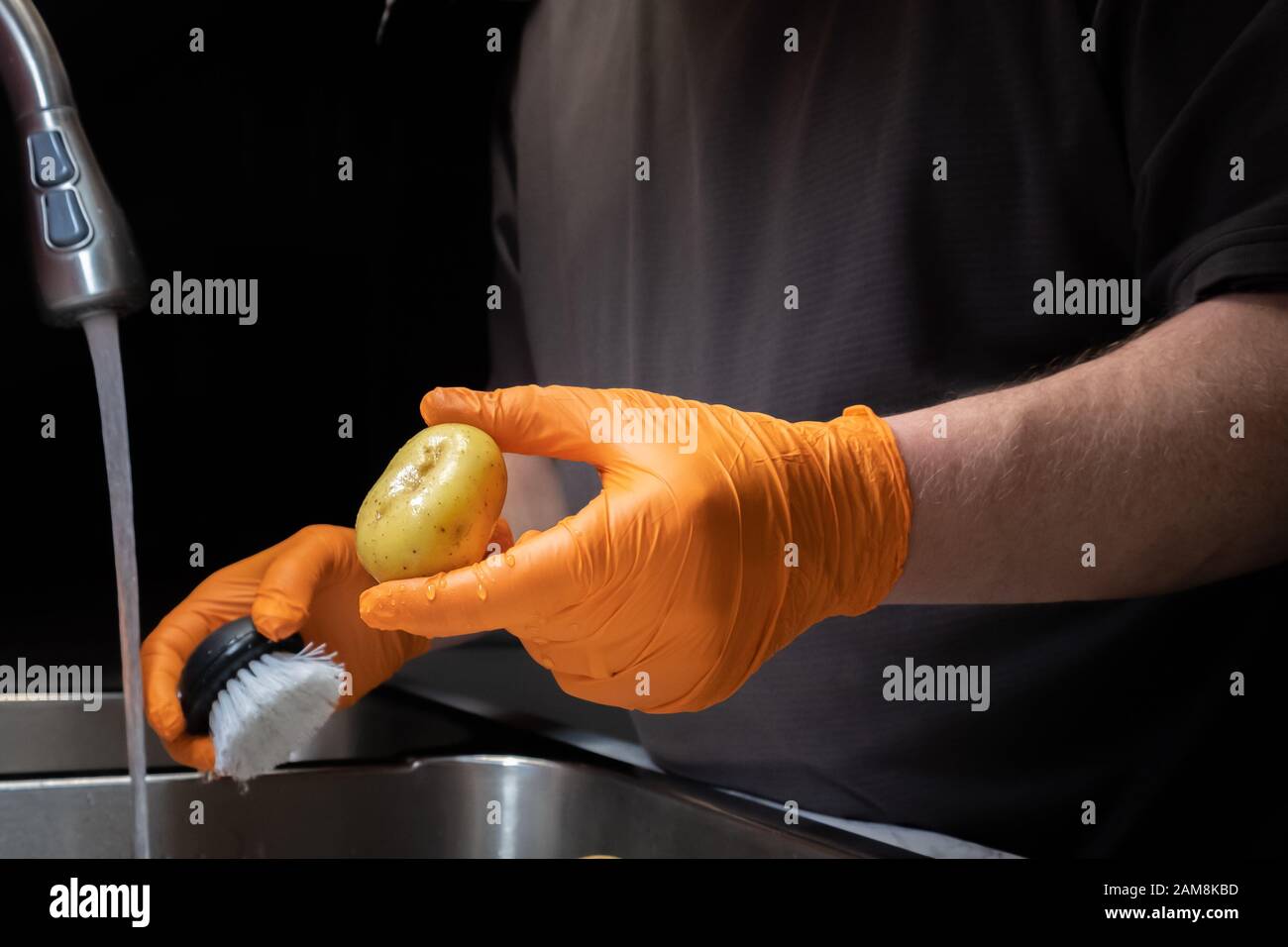 Washing and rinsing potatoes in preparation for cooking. Model holding