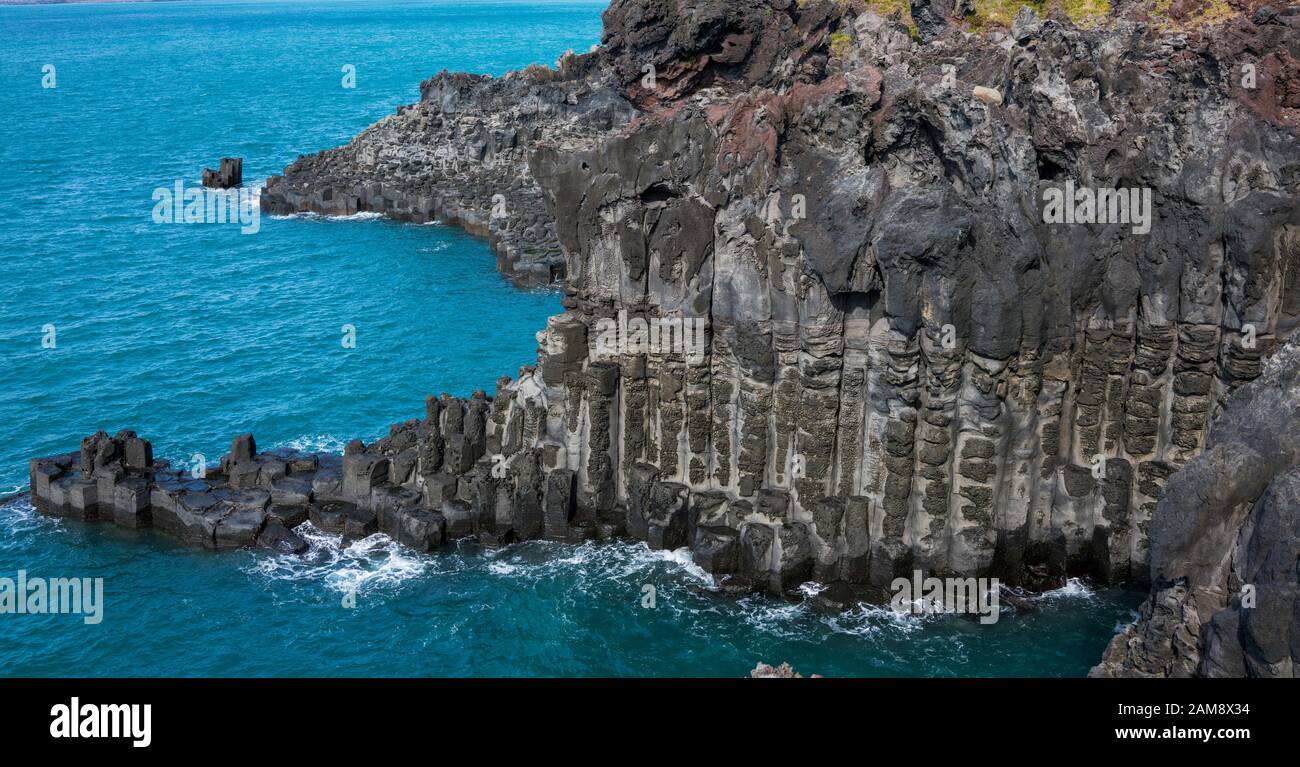 View of the Jusangjeollidae. Jusangjeolli are stone pillars piled up along the coast and is a designated cultural monument of Jeju Island. Jusangjeoll Stock Photo
