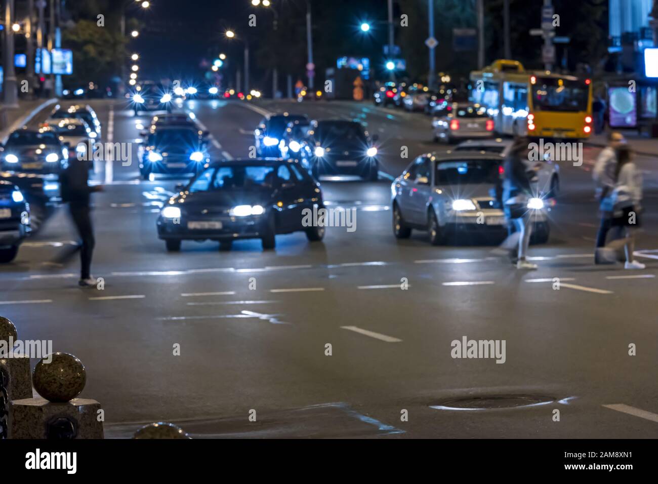 people walking over crossroad on night city street. blurred image Stock Photo