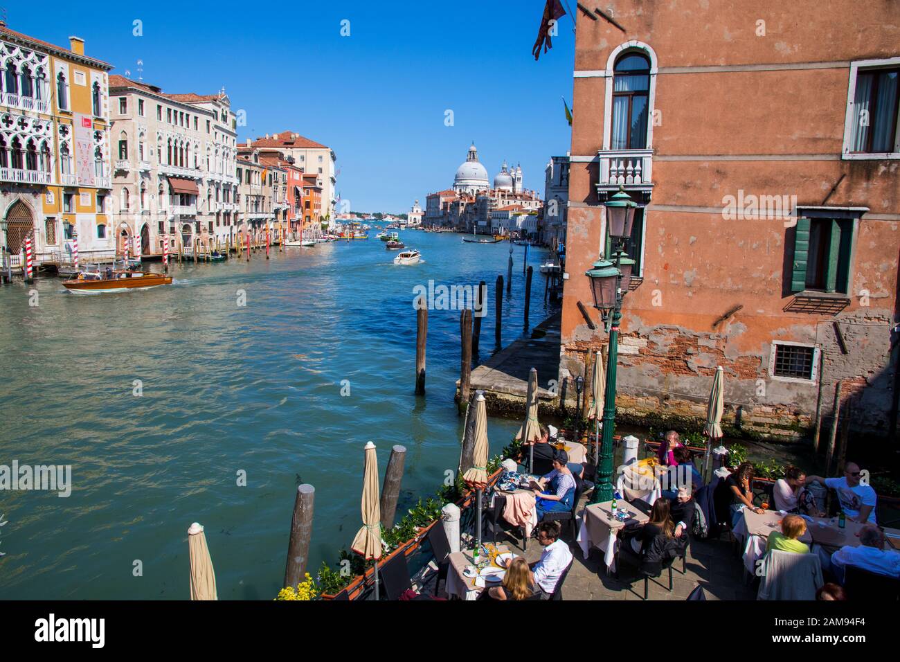 People sitting in a cafe overlooking the Grand Canal in Venice Italy Stock Photo