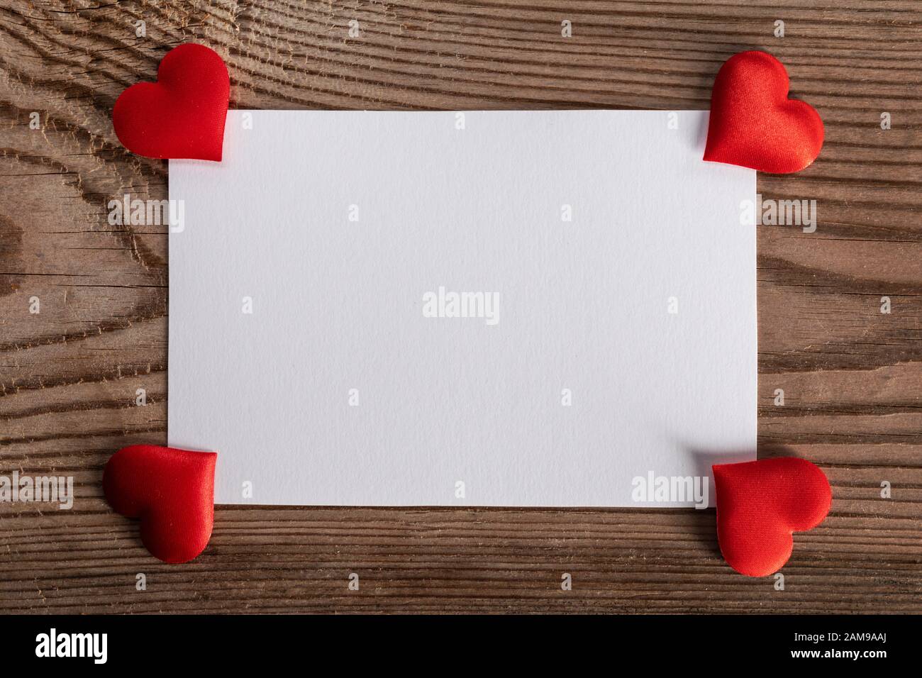 Valentine's day white blank paper greeting card and red silk hearts
