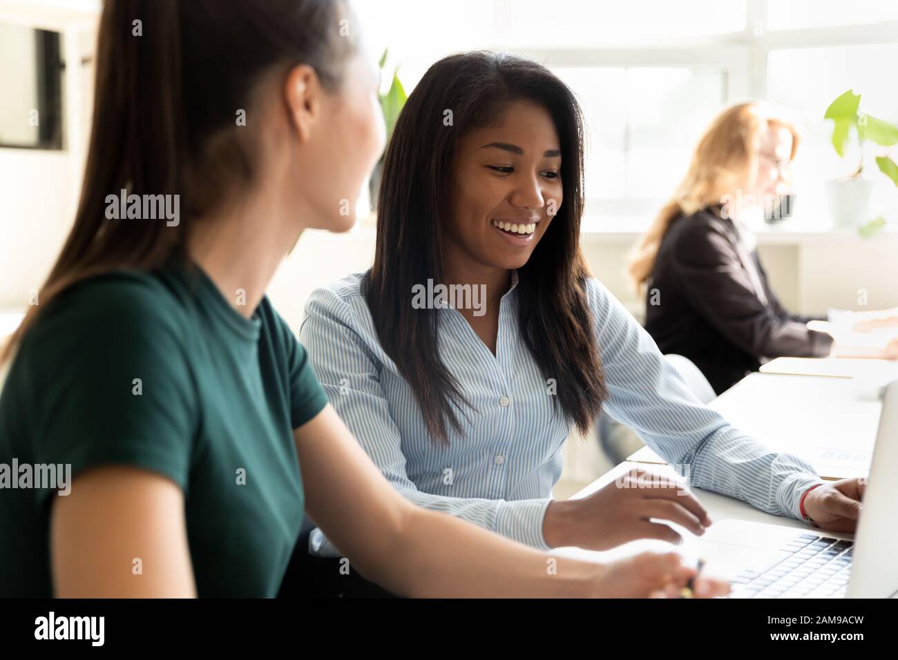 Attractive biracial and european coworkers working on common project Stock Photo