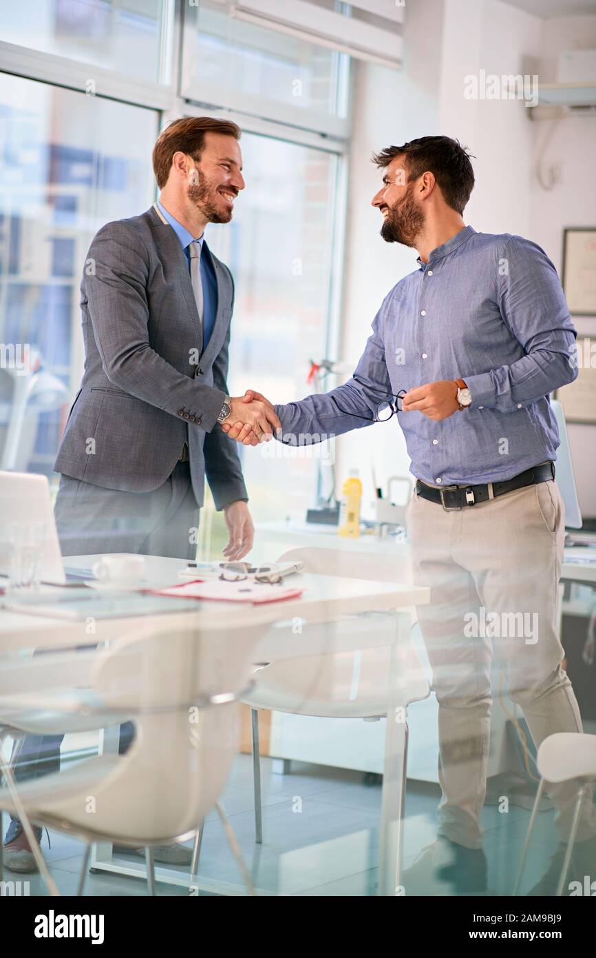 Successful smiling business mens completed business meeting with ...