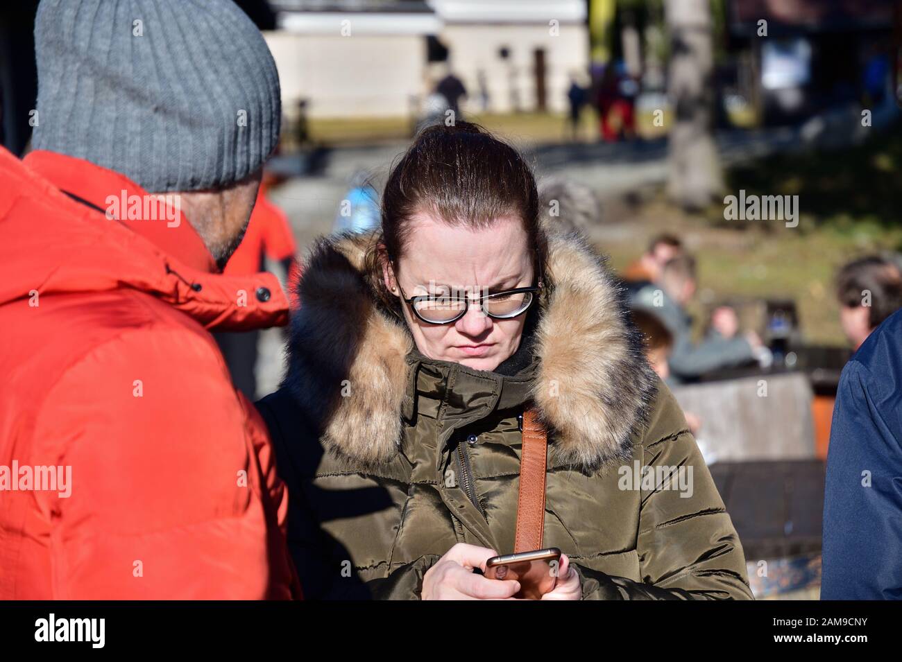 A woman in love looks into her cell phone and sends a text message to her family Stock Photo