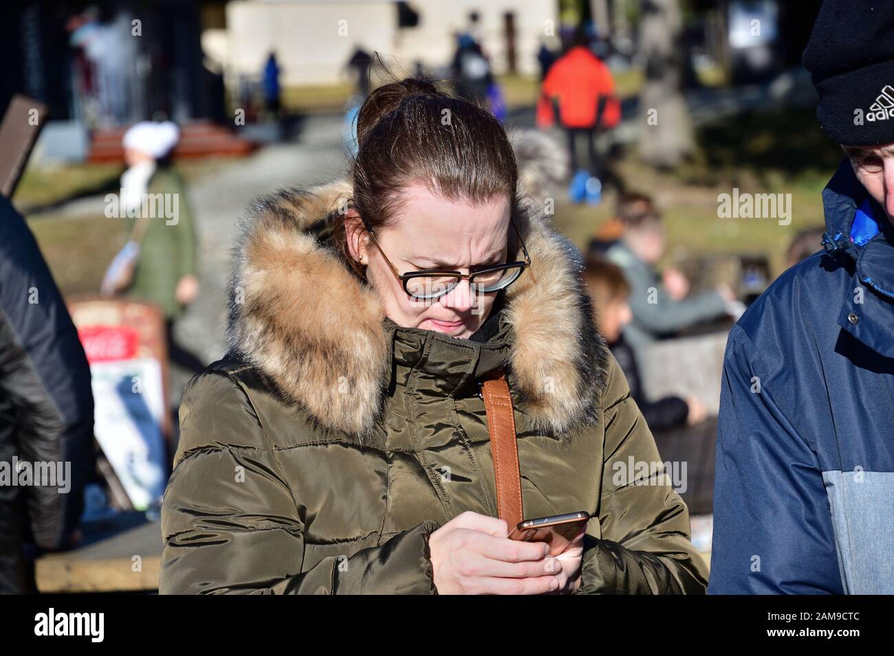A woman in love looks into her cell phone and sends a text message to her family Stock Photo