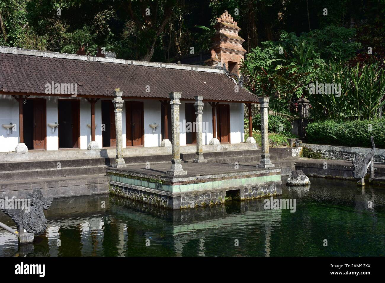Changing rooms with tiny sinks on exterior wall next to outdoor pool of water palace Tirta Gangga in Bali. Stock Photo