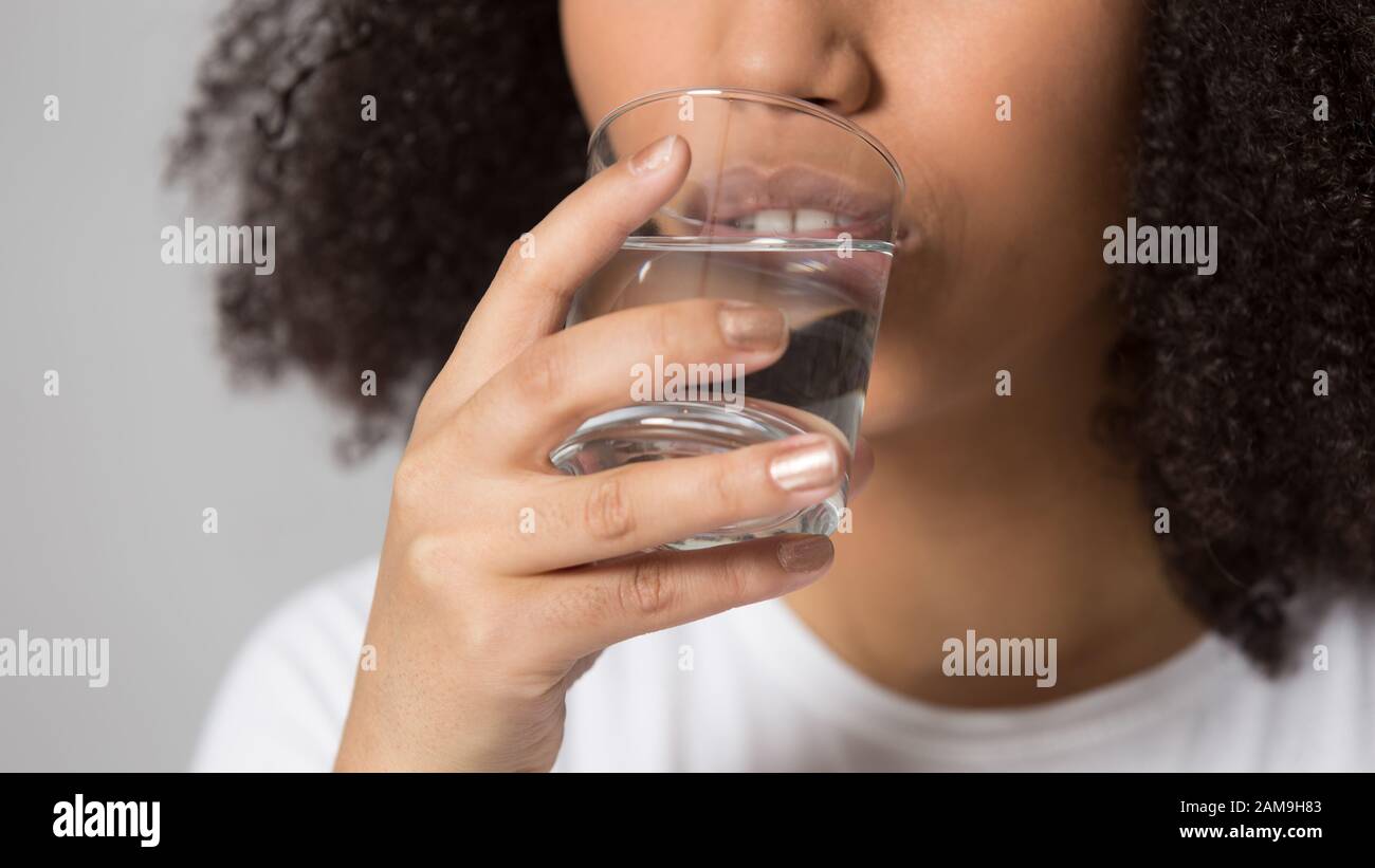 Close up head shot portrait african american lady drinking water. Stock Photo