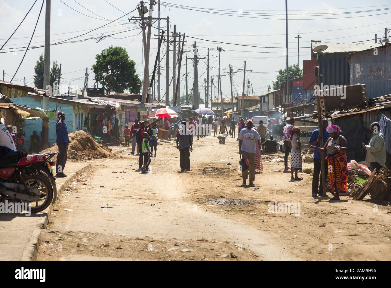 Locals going about daily life on a large road through Korogocho slum, Nairobi, Kenya Stock Photo