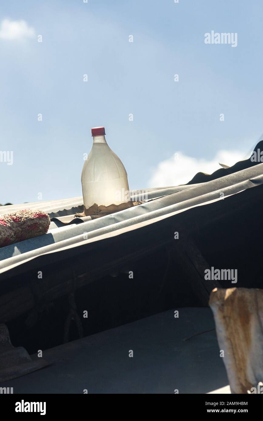Corrugated shack roof with solar clear plastic water bottle, filled with  bleach and water it acts as a natural light bulb inside the building Stock  Photo - Alamy