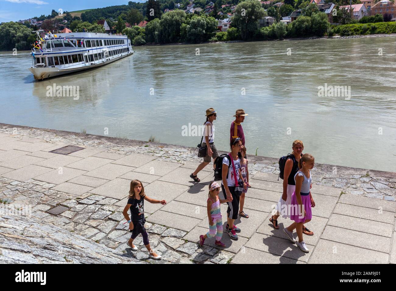 People, tourists, family walking river embankment Passau Germany European river cruise, River Inn countryside Stock Photo