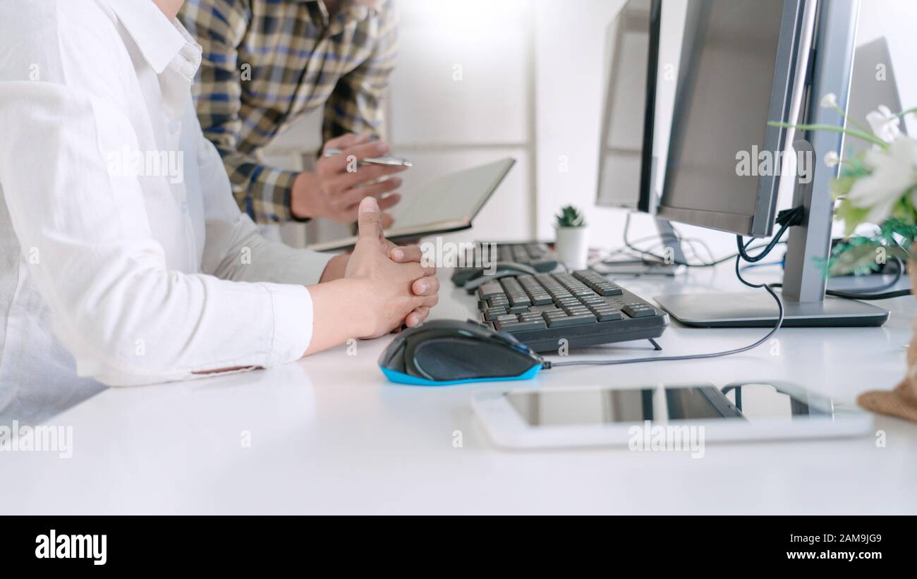 Young startup Programmers Sitting At Desks Working On Computers screen for Developing programming and coding to find solution to problem on New Applic Stock Photo