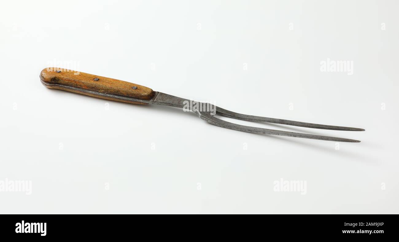 Old carving / meat fork with wood handle Stock Photo