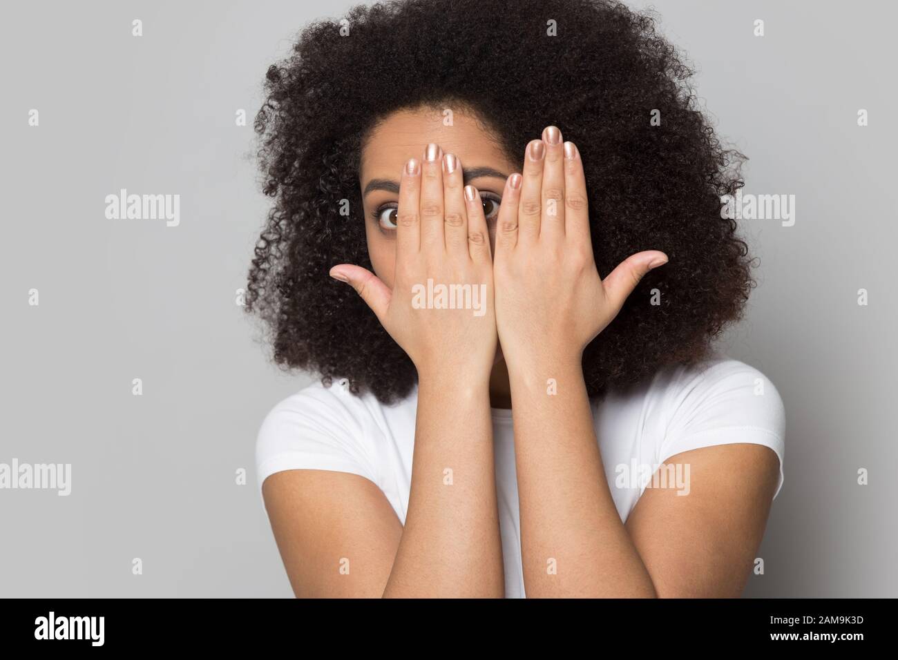 Stressed worried african american young lady looking out of hands. Stock Photo