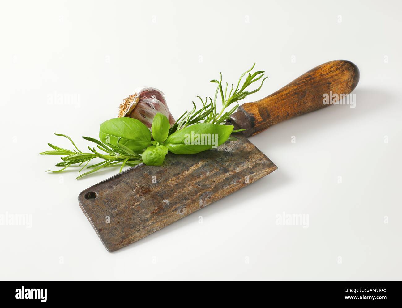 https://c8.alamy.com/comp/2AM9K45/old-rusty-meat-cleaver-knife-with-fresh-basil-and-rosemary-2AM9K45.jpg