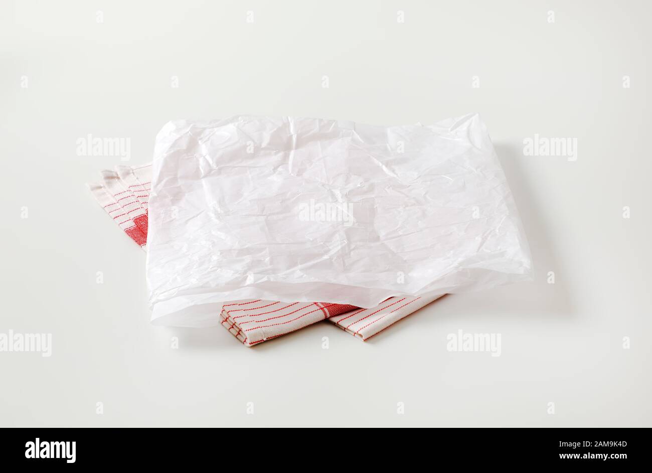 Creased sheet of white wax paper (butcher paper) on tea towel Stock Photo