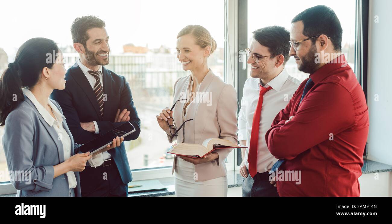 Business people standing by the window discussing a project Stock Photo