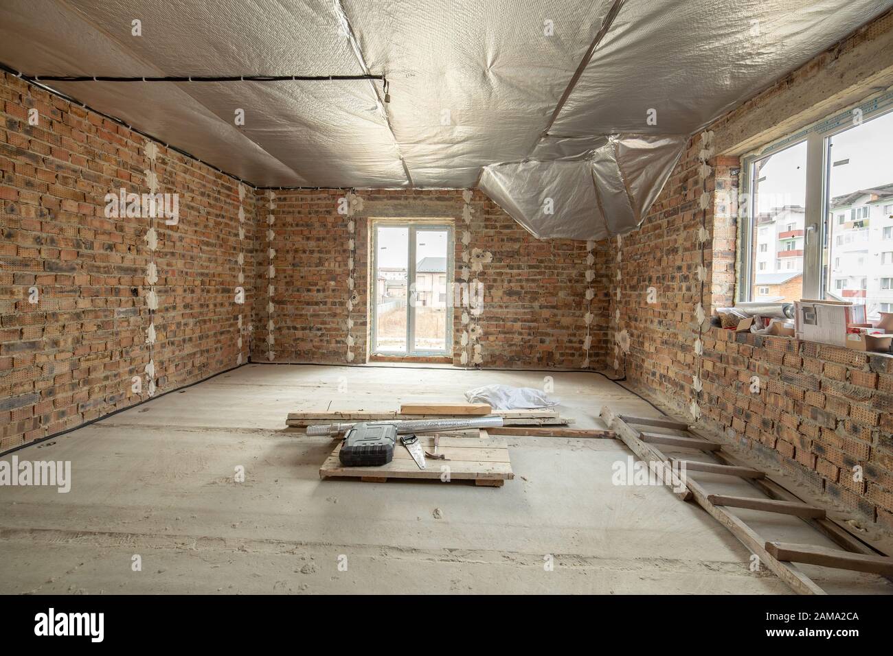 Interior Of Unfinished Brick House With Concrete Floor And Bare