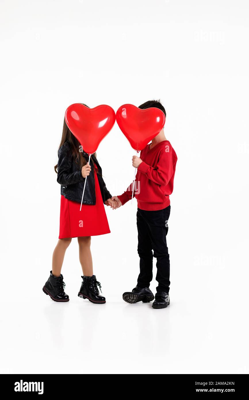 couple child girl and boy holding red heart balloons isolated on white ...