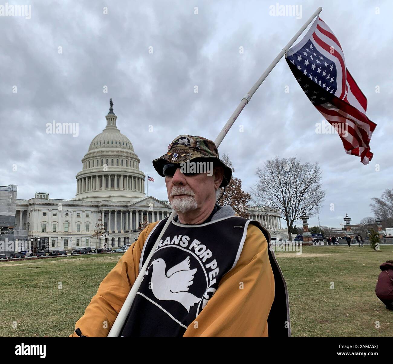 January 10, 2020, Washington, District of Columbia, USA: Decorate Vietname veteran Michael Marceau stands in front of the US Capitol holding an inverted US flag. Flying a flag upside down is ''a signal of dire distress in instances of extreme danger to life or property'' - in his case symbolizing the call that our nation is in distress. (Credit Image: © Sue Dorfman/ZUMA Wire) Stock Photo