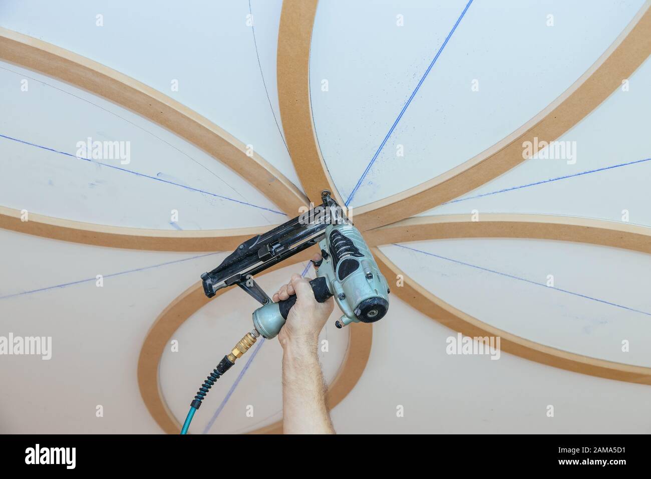 Installation of decorative mouldings on the ceiling carpenter using