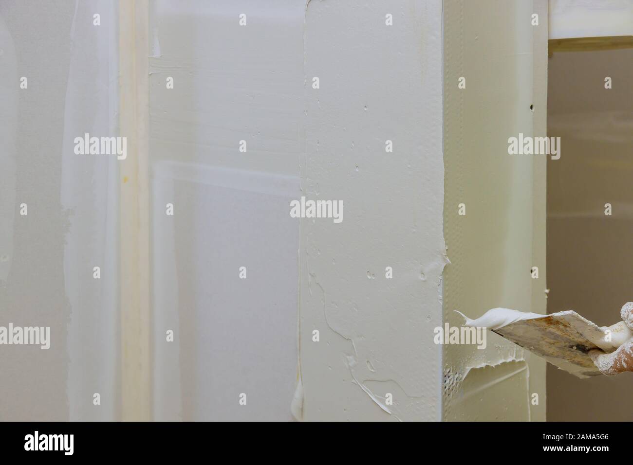 Work hand tool wall using plastering tool for unfinishing wall Stock Photo
