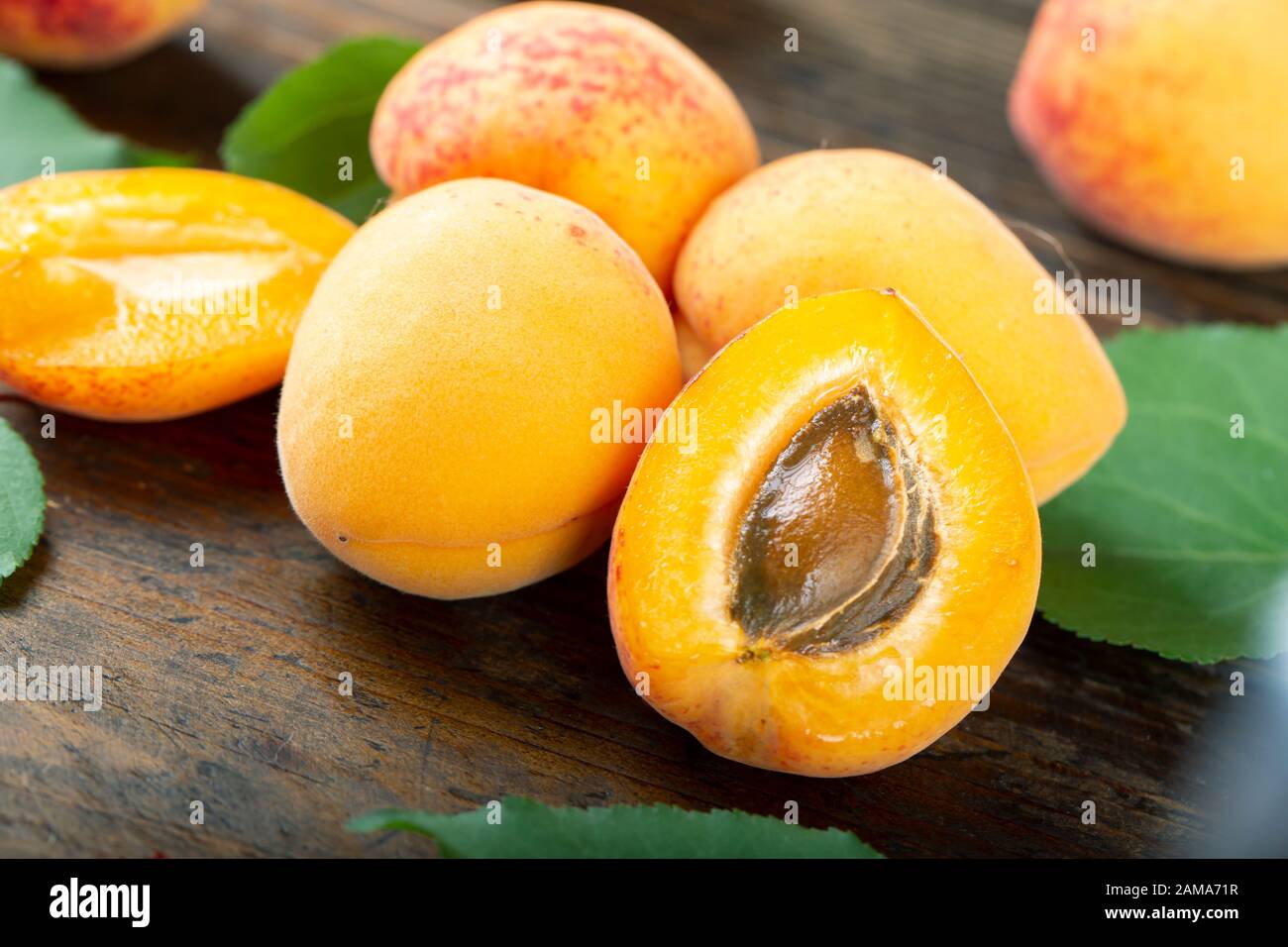 ripe organic apricots on a wooden background. in the foreground half