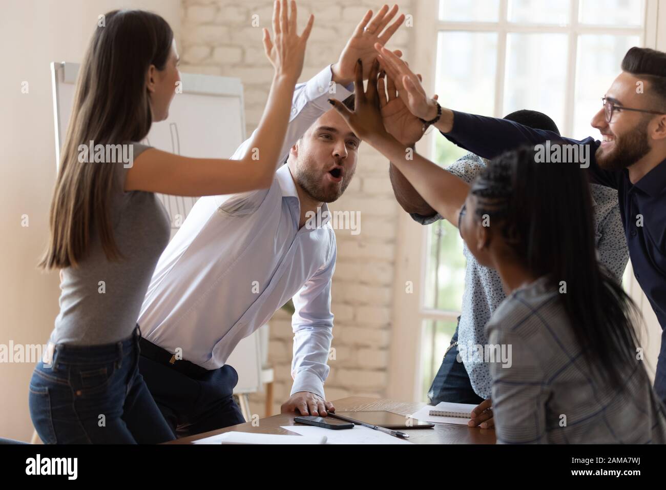 Overjoyed diverse employees give high five celebrating success Stock ...