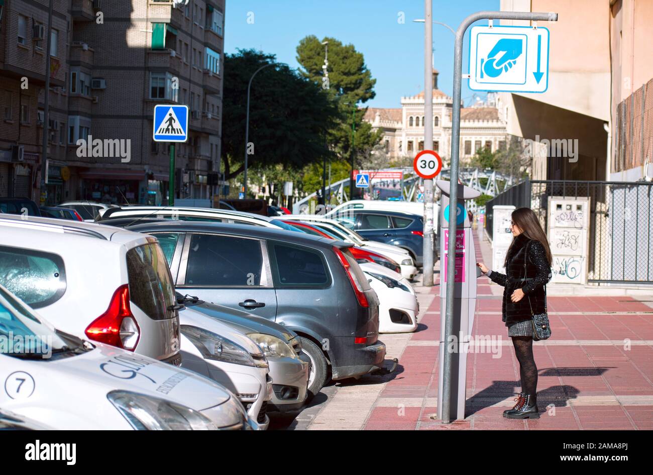 Murcia, Spain, January 11, 2020: Woman paying on ticketing machine to park her car. Stock Photo