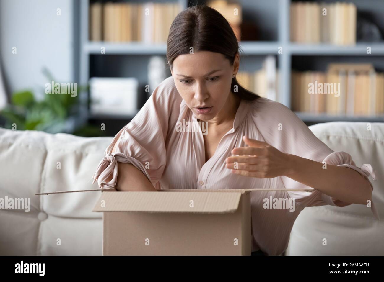 Frustrated woman disappointed with bad quality internet order Stock Photo