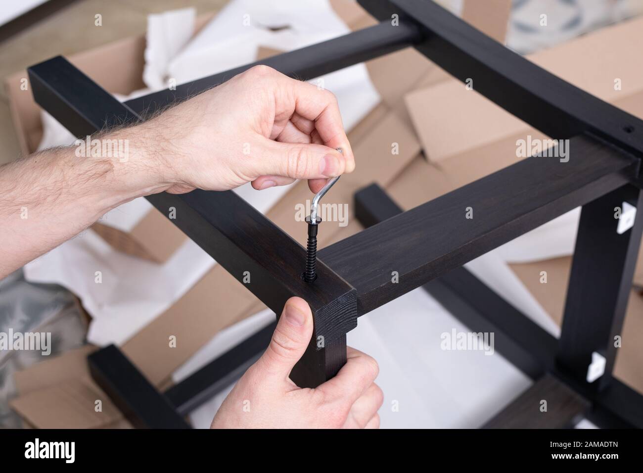 hand uses the allen key screws wood, Allen furniture key in hand. Allen