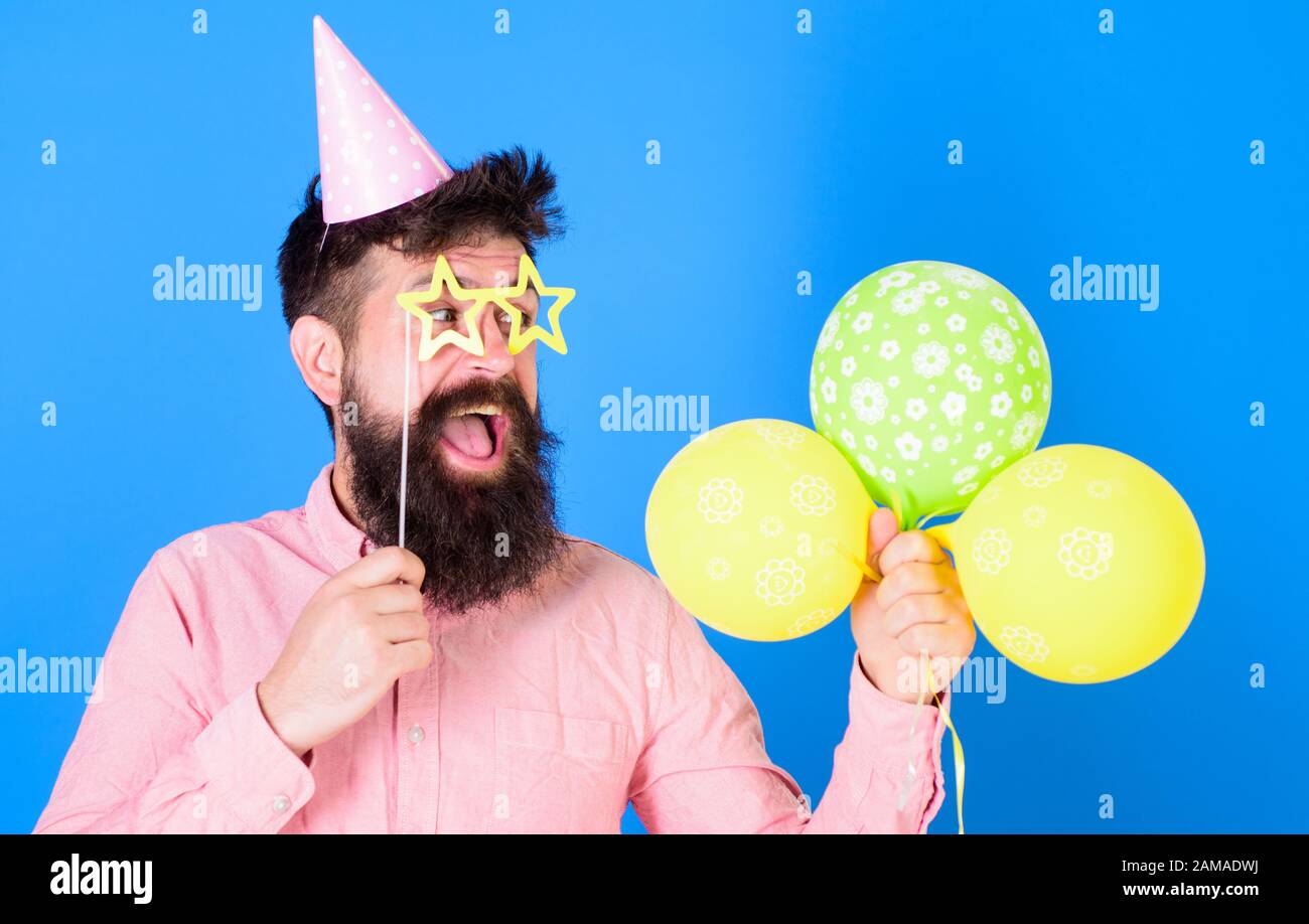 Man with beard and mustache on happy face hold air balloons, blue