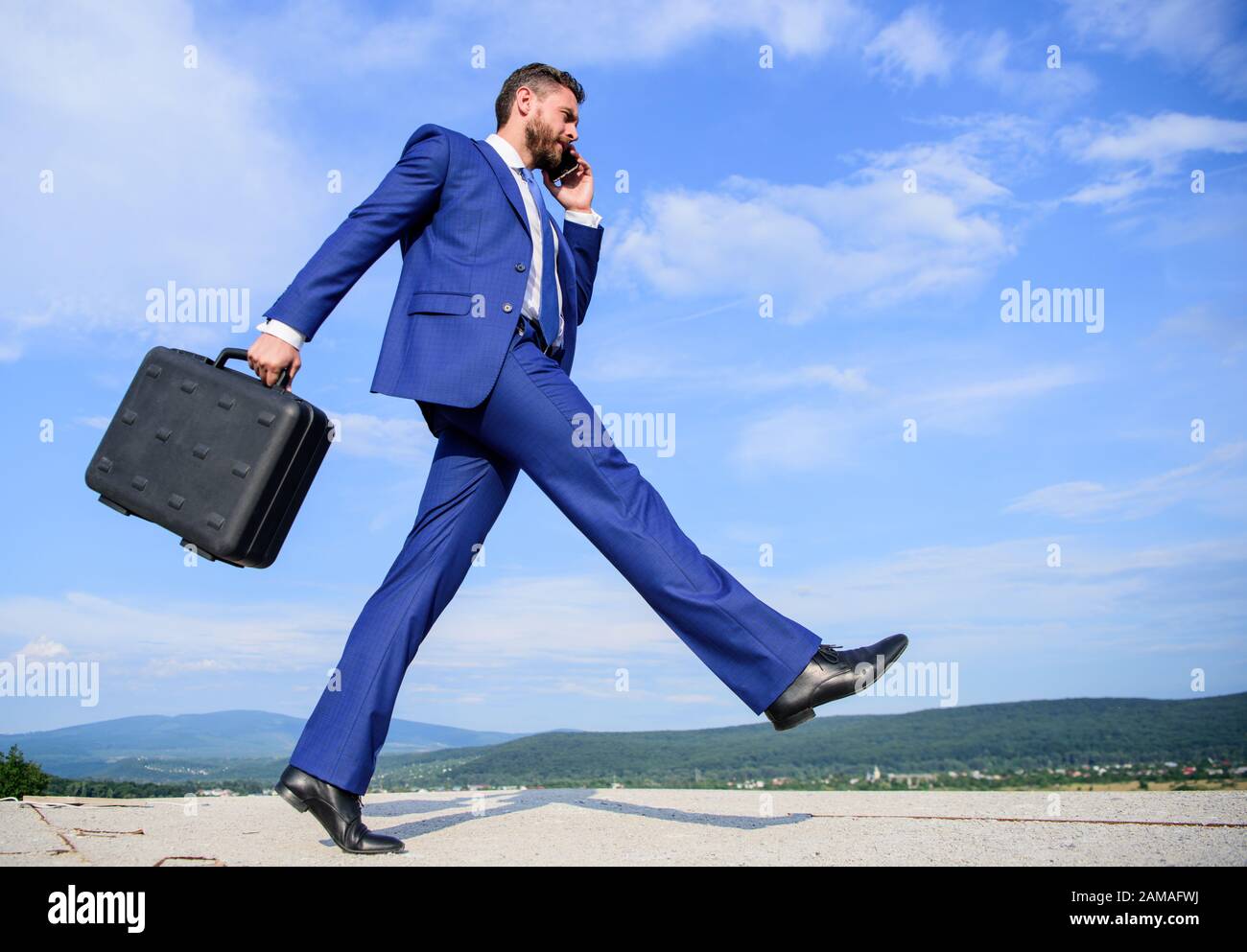 Businessman formal suit carries briefcase sky background. Businessman solving business problems on phone. Never stop. Keep going towards your goal. Entrepreneur in motion purposeful expression. Stock Photo