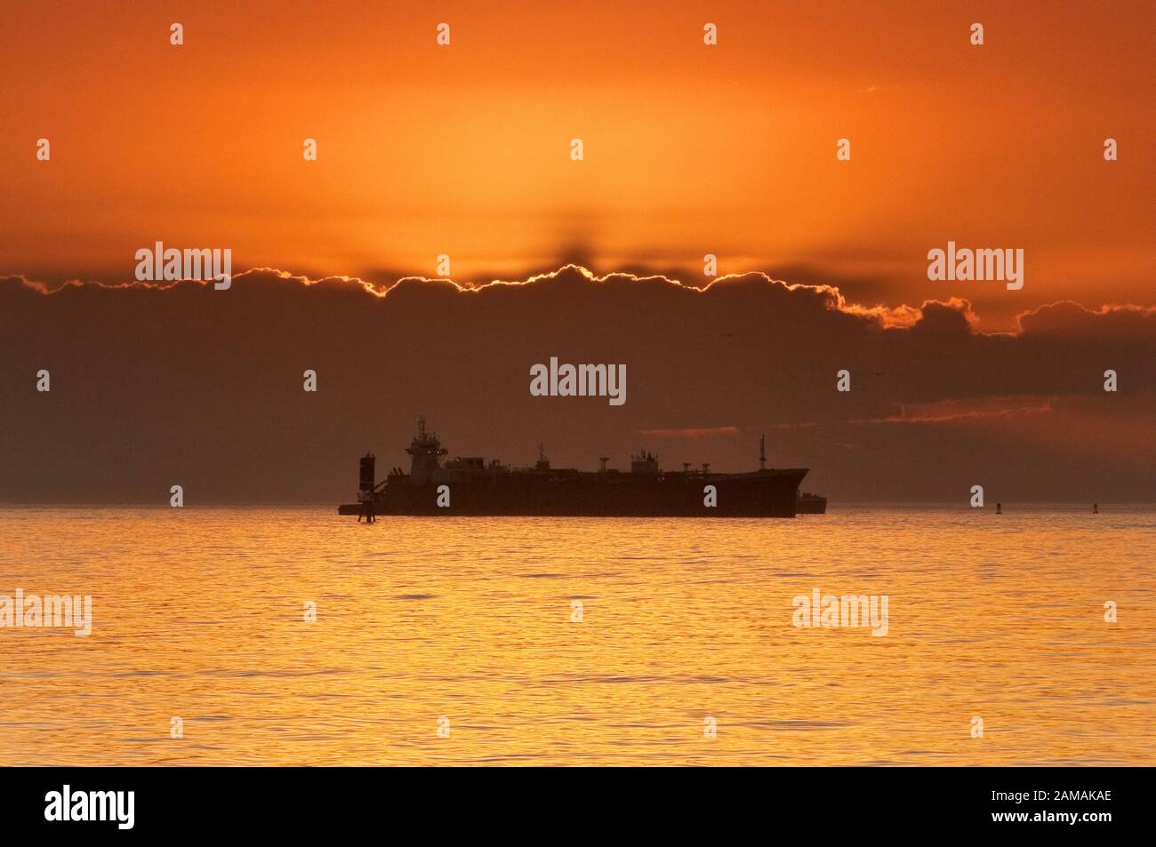 Ships waiting at anchor in Gulf of Mexico at sunrise, before entering Galveston Bay on their way to Port of Houston, Texas, USA Stock Photo