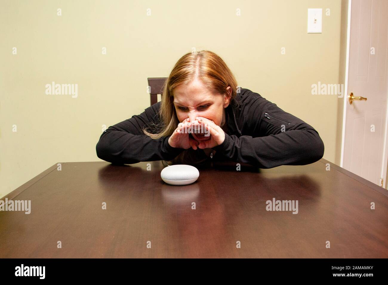 woman yelling at her home assist device because it is not working Stock Photo