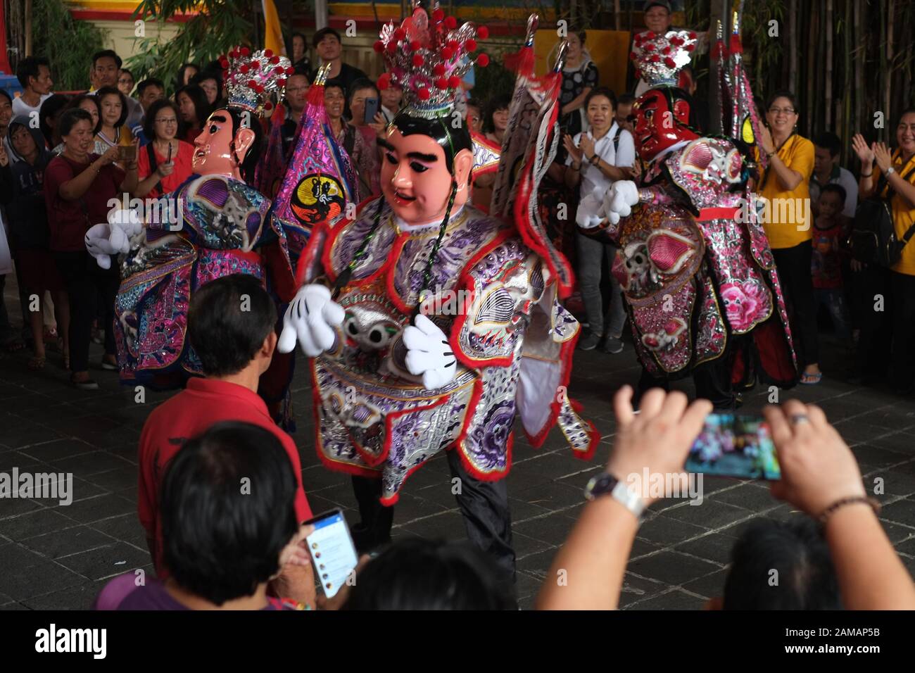 People take pictures of a puppets show using smartphone camera in