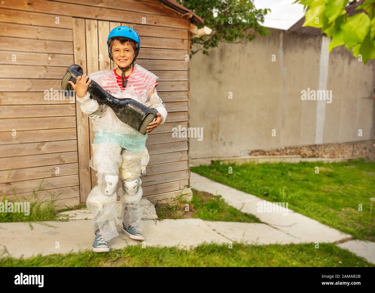 Little boy with hoverboard and overprotective mother keeping a ...