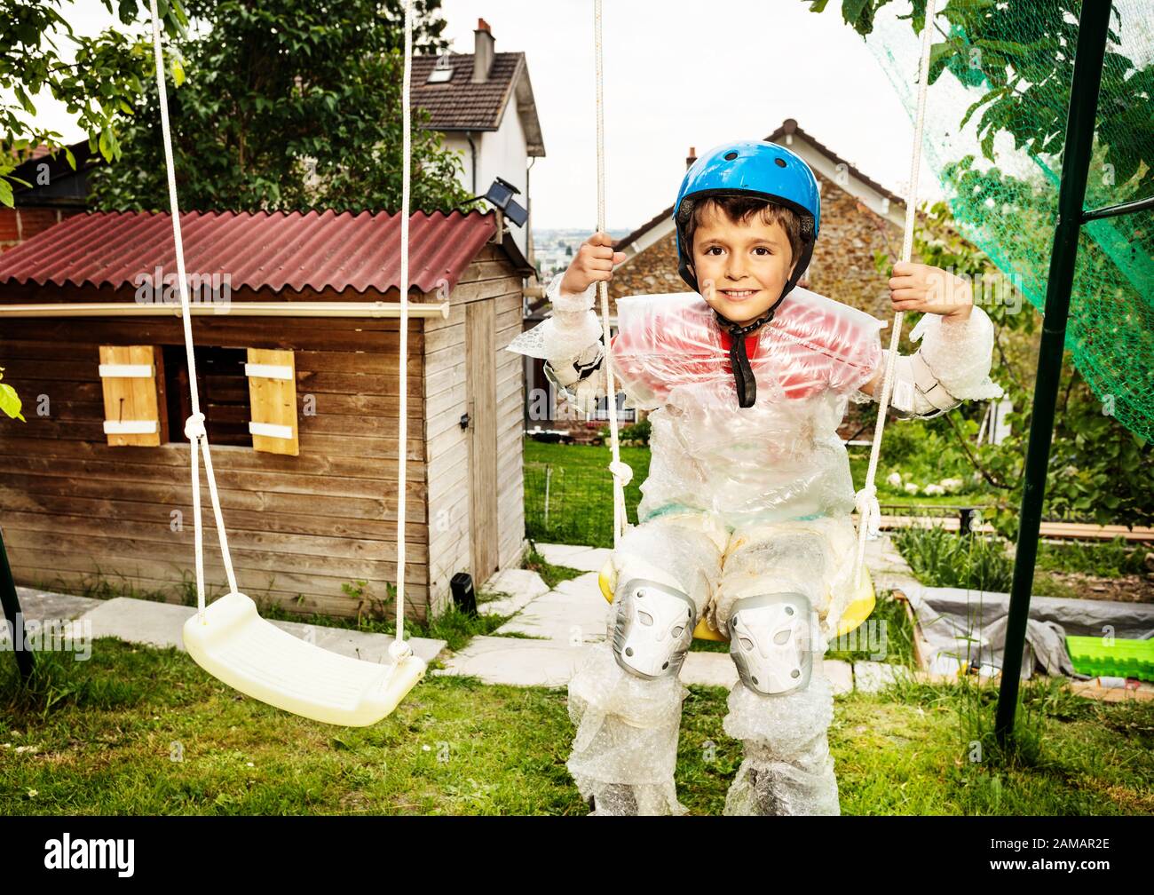 Little boy in super safe bubble wrap material and overprotective mother