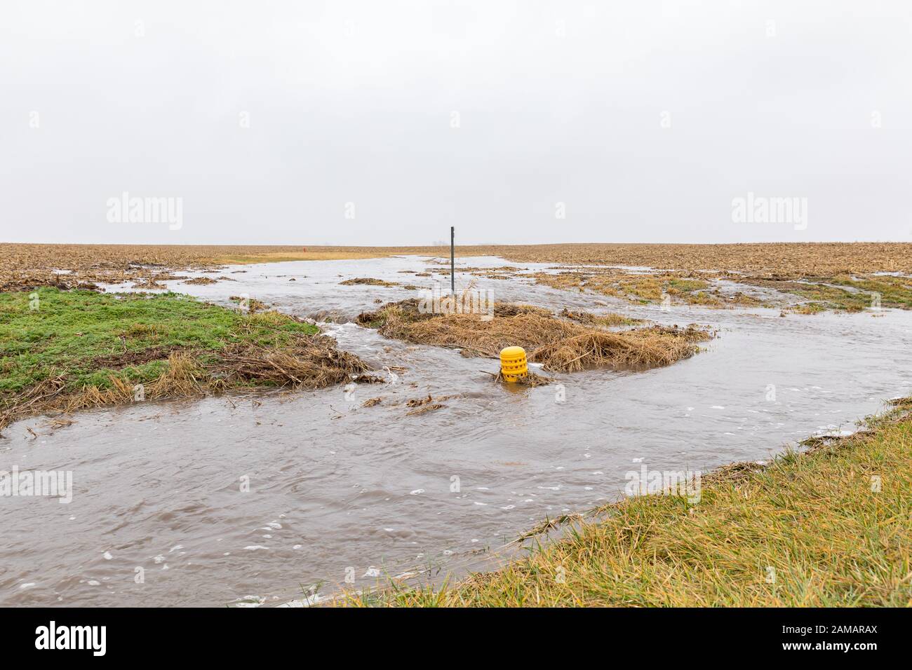 January storms with heavy rain caused flash flooding in farm fields, overflowing ditches and soil erosion from flowing water runoff Stock Photo