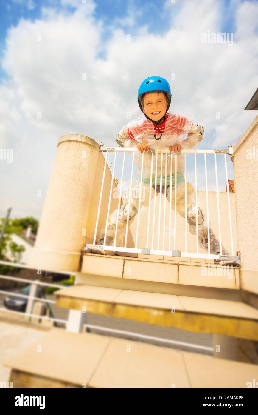 Boy hold children safe door, stairs in bubble wrap and helmet from
