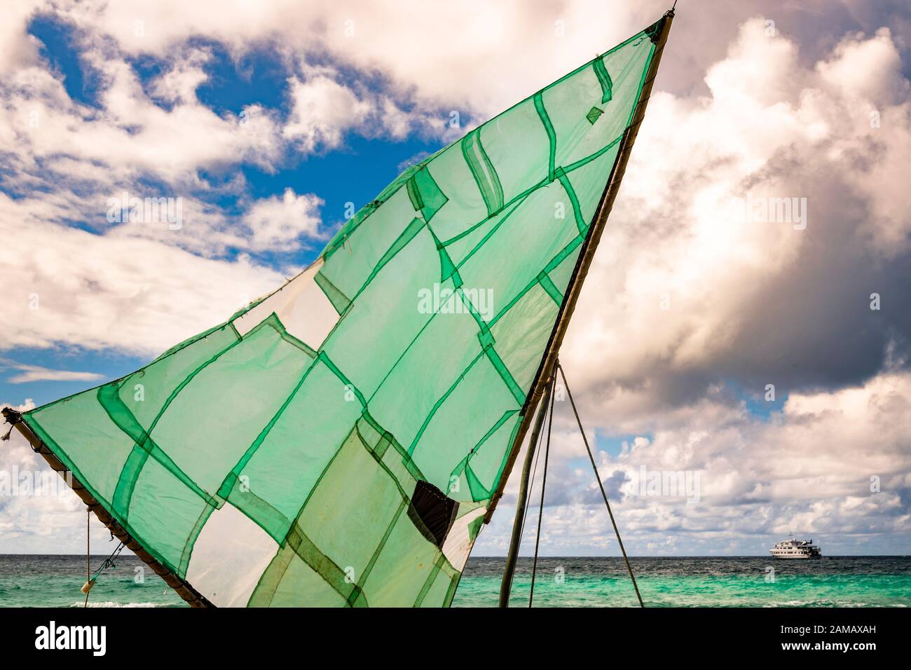 Polynesian sailboat (Prau) on the beach of Yanaba Island from Papua New Guinea. In the background you can see the expedition ship True North Stock Photo