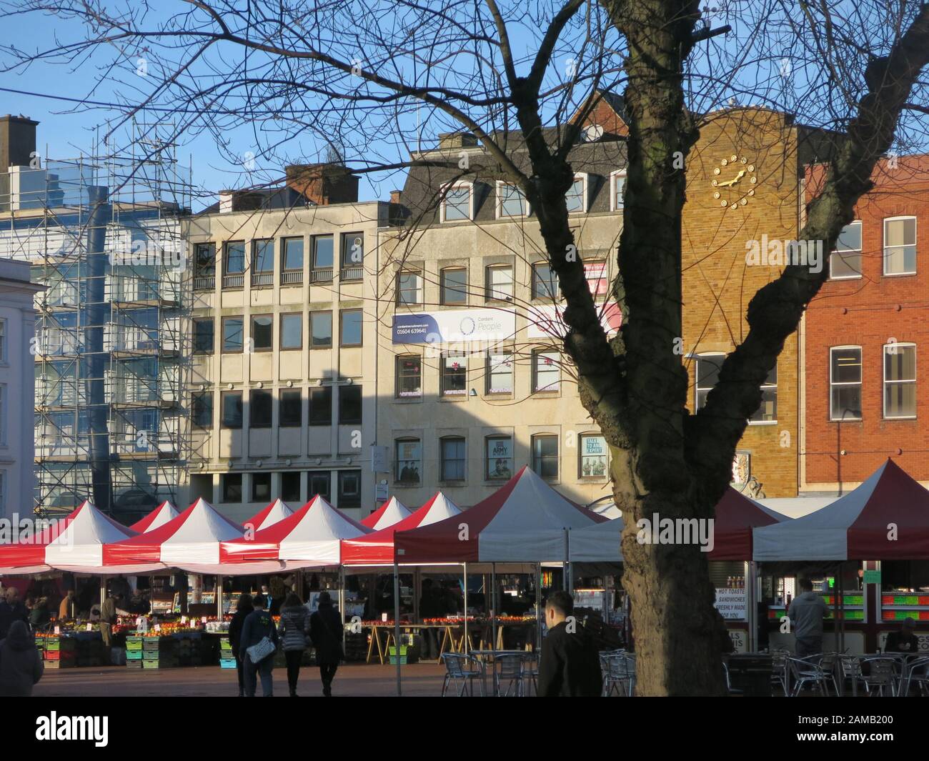 View of the traditional open-air market square in Northampton's town centre with red & white awnings covering the traders' stalls; January 2020 Stock Photo